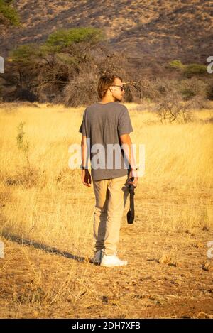 Bärtiger Mann in Sonnenbrille steht mit Kamera Stockfoto