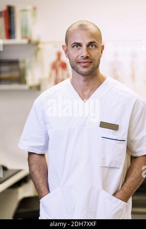 Porträt des selbstbewussten orthopädischen Chirurgen stehend mit Händen in den Taschen In der Klinik Stockfoto