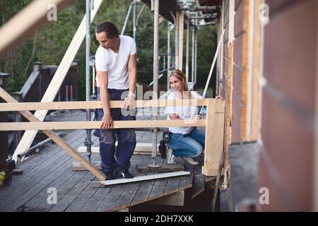 Volle Länge des Paares arbeiten auf der Veranda des Hauses sein Renoviert Stockfoto