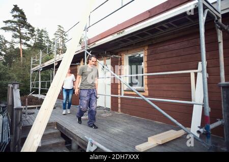 Volle Länge des Paares, das auf der Diele des Hauses ist Renoviert Stockfoto