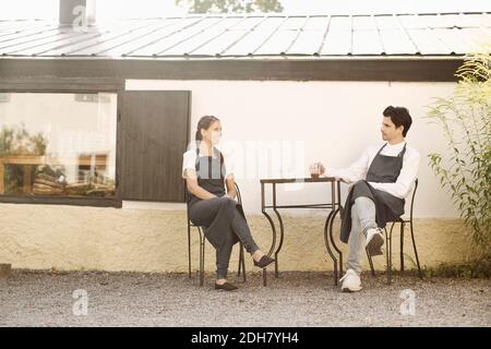 Kellnerin und Kellner machen Kaffeepause vor dem Restaurant Stockfoto