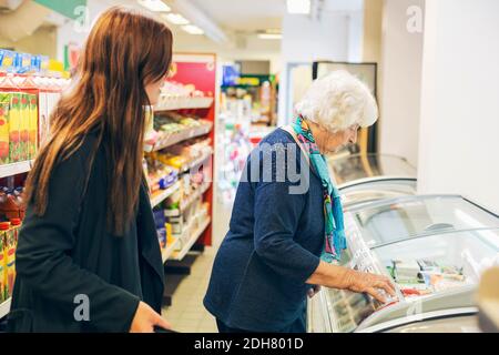 Junge Frau, die Großmutter beim Einkaufen im Supermarkt ansieht Stockfoto