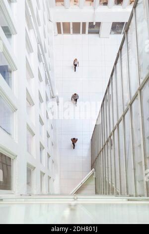 Entferntes Bild von Geschäftsleuten, die in einem modernen Büro in Reihe gehen Stockfoto