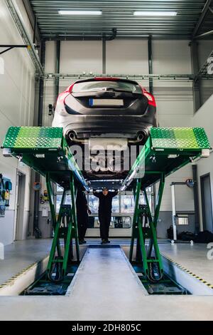 Auto auf Hydrauliklift in der Autowerkstatt Stockfoto