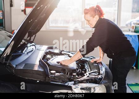 Weibliche Mechaniker Reparatur Auto in Auto-Werkstatt Stockfoto