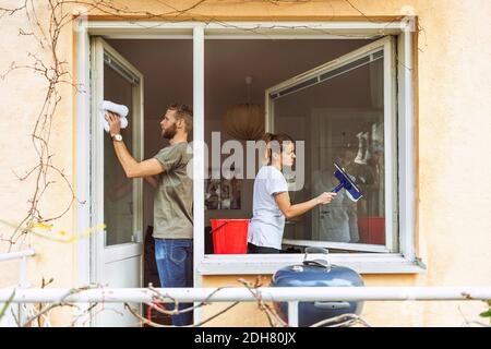 Frau und Mann putzen Fenster zusammen Stockfoto