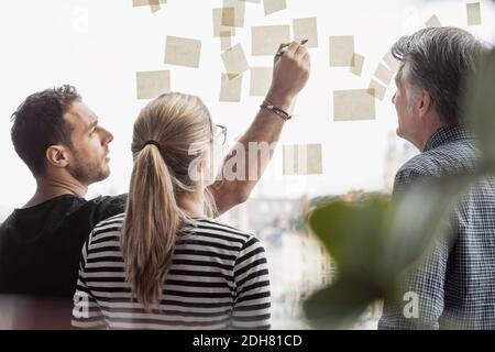 Geschäftsmann erklärt Kollegen im Büro Haftnotizen Stockfoto