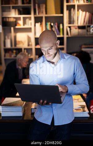 Junger Geschäftsmann mit Laptop im Büro Stockfoto
