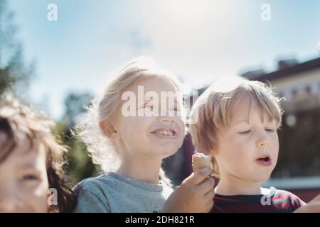 Blick aus der unteren Ecke auf Freunde, die Eis auf dem Hof essen An sonnigen Tag Stockfoto