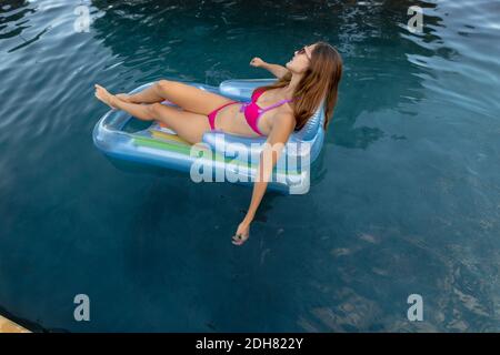 Junge Frau Entspannung im Schwimmbad Stockfoto