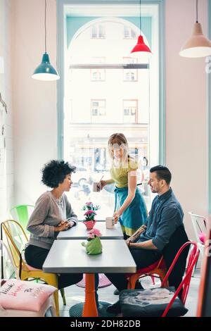Kellnerin serviert den Kunden Kaffee im Coffee Shop Stockfoto