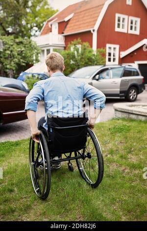 Rückansicht des Rollstuhlfahrers auf dem Hof Stockfoto