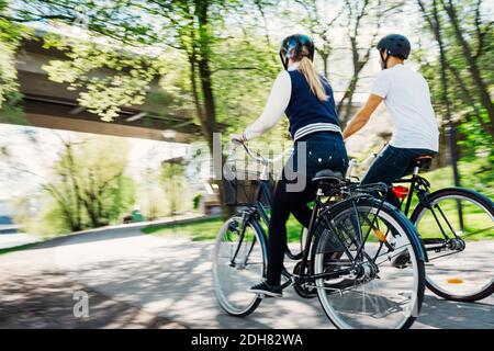 Rückansicht von Geschäftsleuten, die auf der Straße Fahrräder fahren Stockfoto