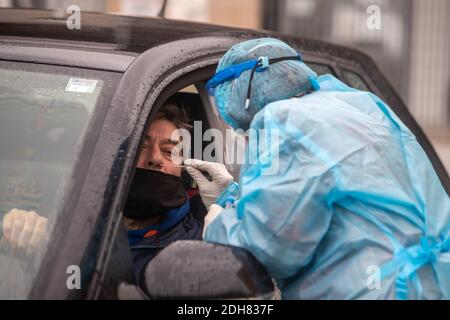 Thessaloniki, Griechenland - 10. Dezember 2020. Ein Arzt, der einen speziellen Anzug zum Schutz vor Coronaviren trägt, führt einen Schnelltestin durch Stockfoto