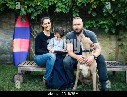 Portrait der Familie, die mit Hund auf dem Hof sitzt Stockfoto