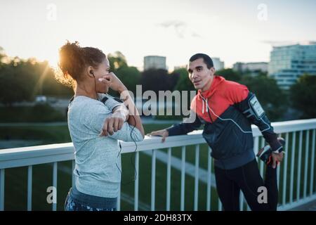 Freunde trainieren beim Stehen am Geländer auf dem Bürgersteig Stockfoto