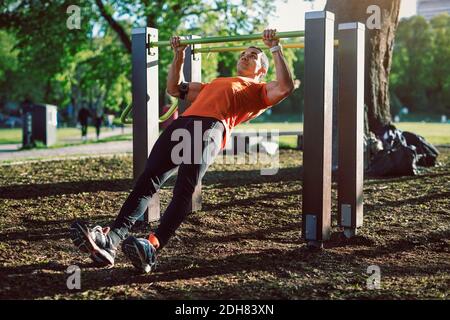 Mann, der am Geländer im Park trainiert Stockfoto
