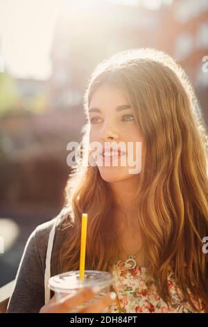 Nachdenklich Teenager-Mädchen hält Einweg-Glas im Freien Stockfoto