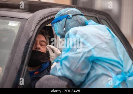 Thessaloniki, Griechenland - 10. Dezember 2020. Ein Arzt, der einen speziellen Anzug zum Schutz vor Coronaviren trägt, führt einen Schnelltestin durch Stockfoto