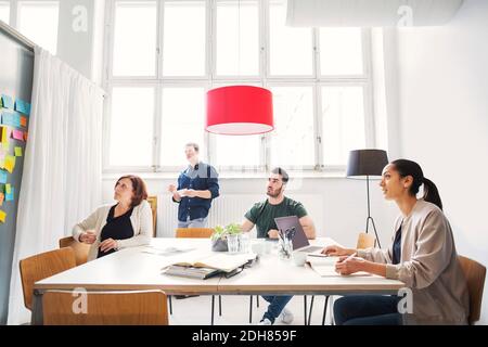 Ein Team von Geschäftsleuten hört sich die Präsentation im Tagungsraum an Stockfoto