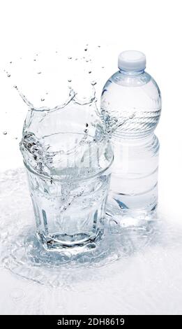 Wasserglas spritzt und Plastikflasche auf gewellter Welle Stockfoto