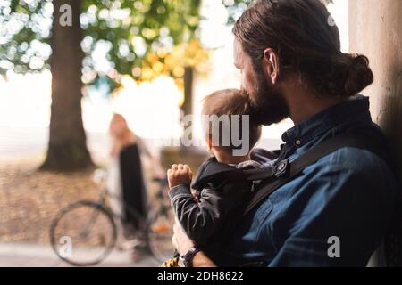 Vater an der Tür hält Baby Junge beim Blick auf Frau Zur Arbeit gehen Stockfoto