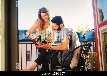 Ein Paar liest zusammen den Reiseführer auf dem Balkon Stockfoto