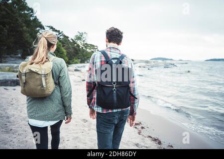 Rückansicht des wonderlust Paares, das am Strand zusammen läuft Stockfoto