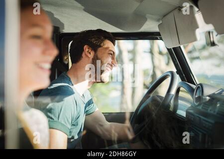 Seitenansicht eines glücklichen Paares, das einen Roadtrip genießen kann Stockfoto