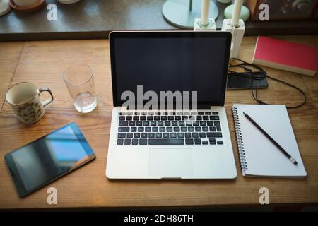 High-Angle-Ansicht der Technologien mit Notizblock auf dem Tisch Im Home Office Stockfoto