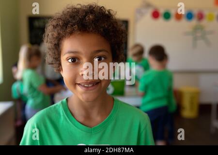 Schuljunge, der ein grünes T-Shirt mit einem weißen Recycling-Logo trägt Stockfoto
