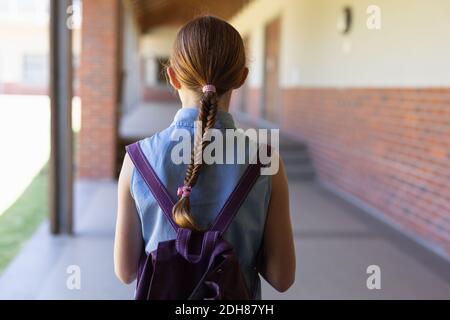 Schulmädchen steht auf dem Schulhof an der Grundschule Stockfoto