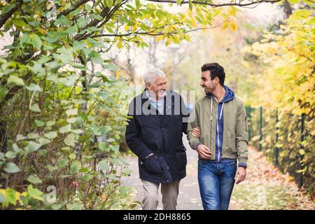 Glücklicher älterer Mann mit Hausmeister, der im Park läuft Stockfoto