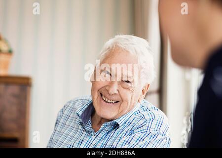 Glücklicher älterer Mann, der Hausmeister im Pflegeheim ansieht Stockfoto