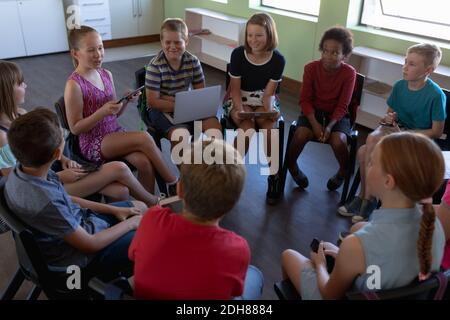 Gruppe von Grundschulkindern, die im Kreis sitzen Stockfoto
