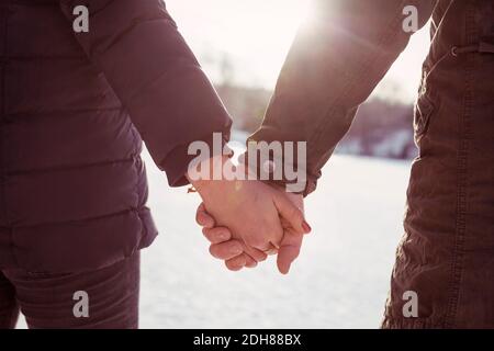 Beschnittenes Bild Wanderer mit Mann und Frau, die im Winter die Hände halten Stockfoto