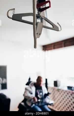 Nahaufnahme der Maschinenausrüstung, die mit einem behinderten Mann im Hintergrund hängt Stockfoto
