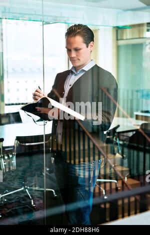 Schöner Geschäftsmann Schreiben Dokument im Büro Stockfoto