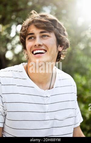 Nahaufnahme eines lächelnden jungen Mannes, der wegschaut Stockfoto