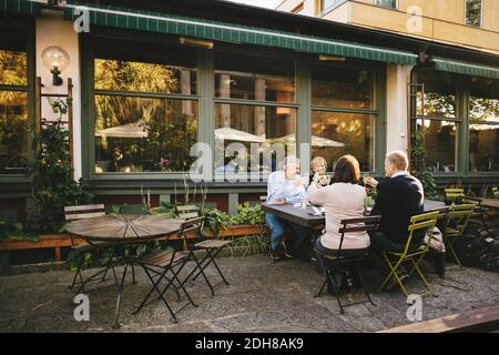 Glückliche ältere Paare, die im Restaurant im Freien Champagner-Flöten genießen Stockfoto