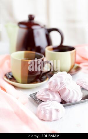 Russische Erdbeeren mit Sahne Marshmallows und Tee auf einem hellen Tisch. Stillleben, selektiver Fokus. Vertikal Stockfoto