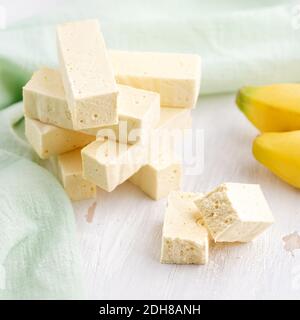 Süßwaren Pastila mit Bananenpüree A auf hellem Tisch. Nahaufnahme, das Stillleben, selektiver Fokus. Vertikal Stockfoto