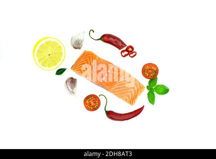 Stück Lachs isoliert auf weiß, Knoblauch, rote Chilischote Zitrone, Tomate. Top Stockfoto