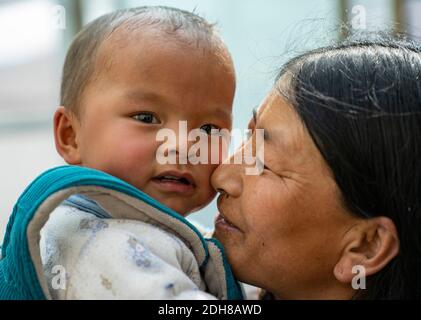 (201210) -- LHASA, 10. Dezember 2020 (Xinhua) -- EIN Dorfbewohner interagiert mit einem Kind in der Gemeinde Pumaqangtang im Landkreis Nagarze in Shannan, südwestlich der Autonomen Region Tibet, 15. April 2020. Pumaqangtang, Chinas höchste Gemeinde, hat eine durchschnittliche Höhe von 5,373 Metern, wobei der Sauerstoffgehalt auf Meereshöhe weniger als 40 Prozent beträgt. Die Dorfbewohner hier lebten früher in Erdsteinhäusern ohne Strom, fließendes Wasser, Gemüse oder Obst. Solche harten Lebensbedingungen dauerten bis in die 1970er Jahre an. Heute sind alle Dorfbewohner in Pumaqangtang in bessere Wohnsitze gezogen. Verglichen mit Stockfoto