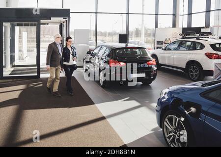 Ältere Männer und Frauen, die in den Autosalon eintreten Stockfoto