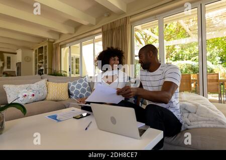 Glückliches junges Paar, das auf dem Sofa diskutiert Stockfoto