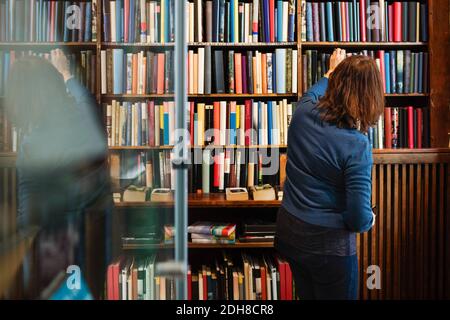 Rückansicht der Bibliothekar, die Bücher im Regal in antiken Kaufen Stockfoto