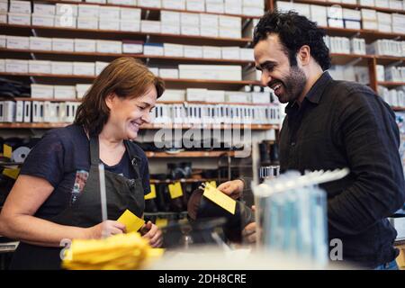 Zufriedener Kunde im Gespräch mit Schuhmacher in der Werkstatt Stockfoto