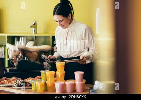 Kellnerin serviert dem Gast Croissant im Café Stockfoto