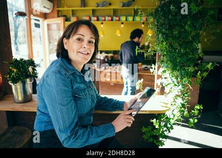 Porträt des glücklichen Besitzers sitzen mit digitalen Tablet im Café Stockfoto